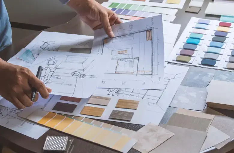 Designer examining sample materials against rough sketches
