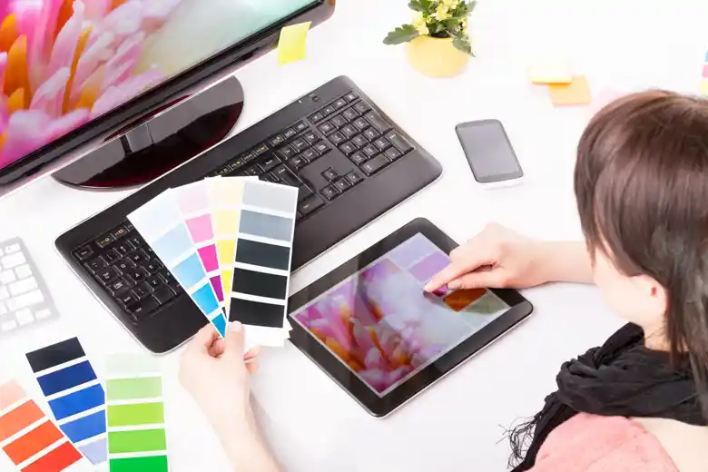 Visual designer examining colour palette of an image on their tablet