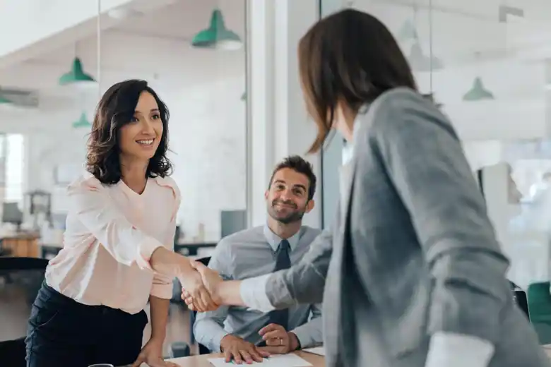 Woman shaking hands with a recruiter after a successful graphic design interview