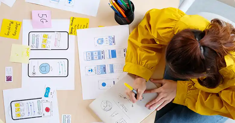 Designer working on UI and UX sketches with various wireframes