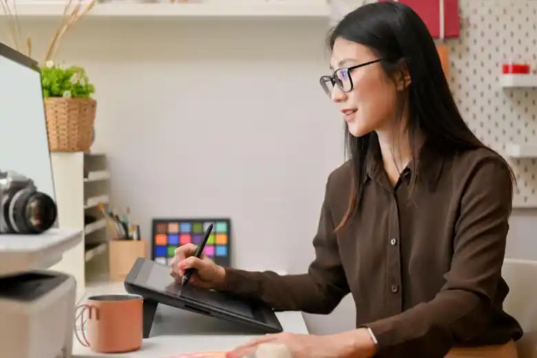 Woman designing using a screen and a tablet Woman designing using a screen and a tablet