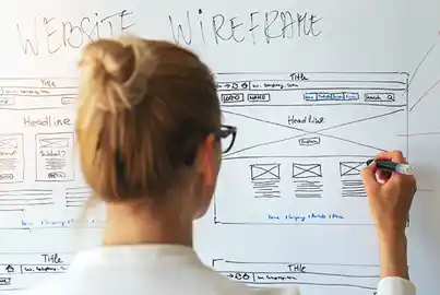 UX designer creating a website wireframe on a white board