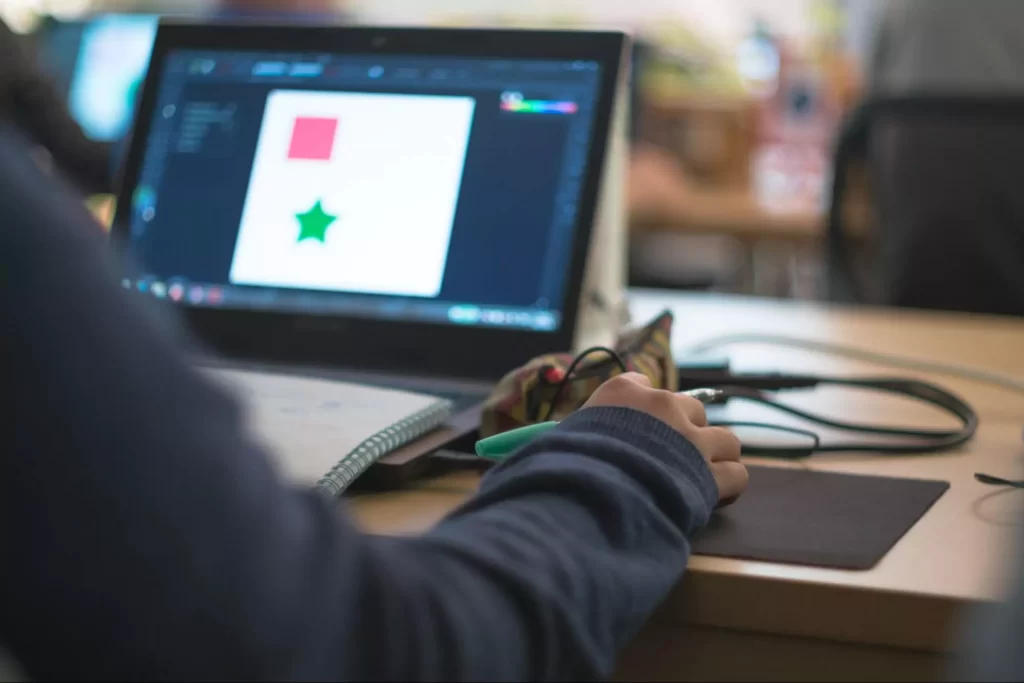A student learning graphic design online. A student learning graphic design online.