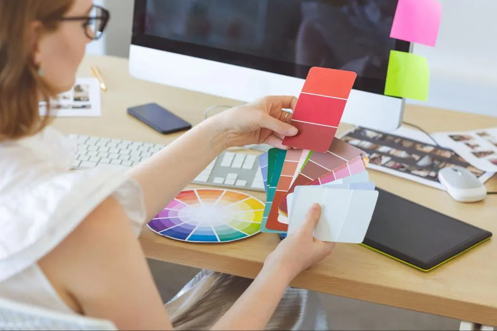 Visual designer examining different colour schemes Visual designer examining different colour schemes