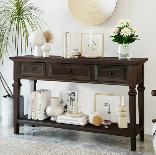 A console table with flower pots, framed photographs and books
A console table with flower pots, framed photographs and books