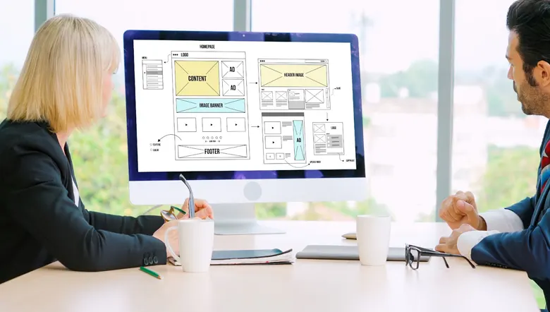 Designers examining wireframes for a landing page Designers examining wireframes for a landing page