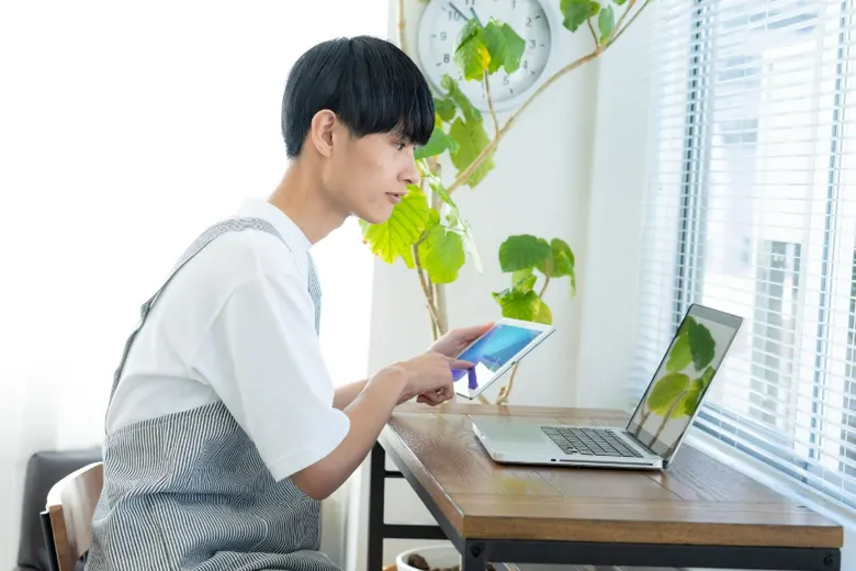 UI designer working on a tab and a laptop UI designer working on a tab and a laptop
