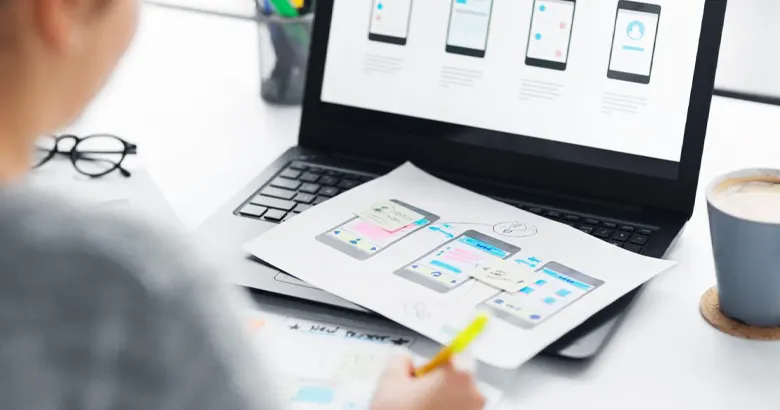 A designer using a UX design software to create a mobile application prototype
