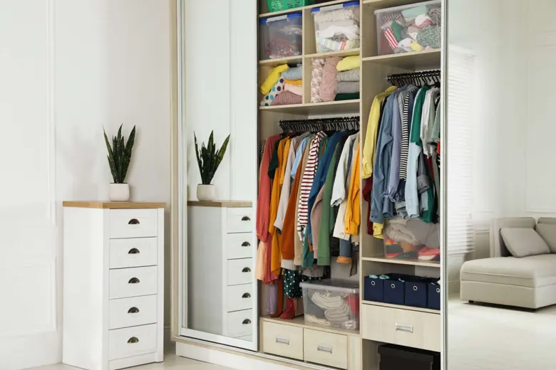Small closet with organisers and clothes on hangers Small closet with organisers and clothes on hangers