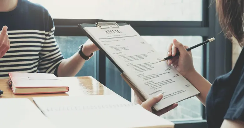 Recruiter interviewing and reviewing a UX UI designer's resume