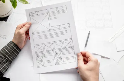 A UI designer sketching a rough wireframe for a website