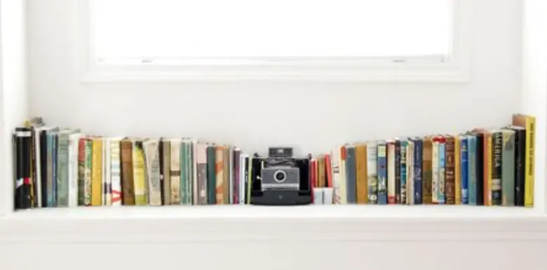 Small bedroom using window sills as bookshelves for additional storage. Small bedroom using window sills as bookshelves for additional storage.