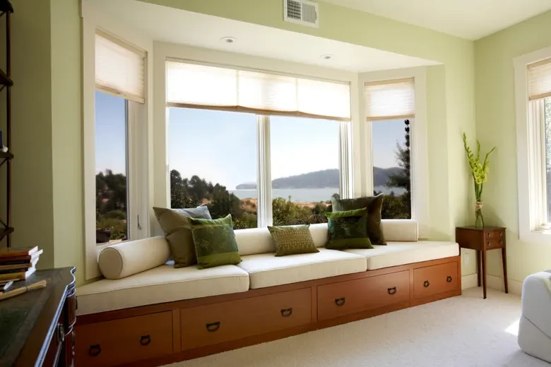Window seating with cushions and storage beneath in a living room.
Window seating with cushions and storage beneath in a living room.