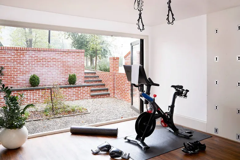 Small workout area with minimal furniture and floor pillows in a living room.
Small workout area with minimal furniture and floor pillows in a living room.