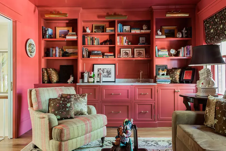 A bookshelf with books, photographs, paintings, and framed photographs.
A bookshelf with books, photographs, paintings, and framed photographs.