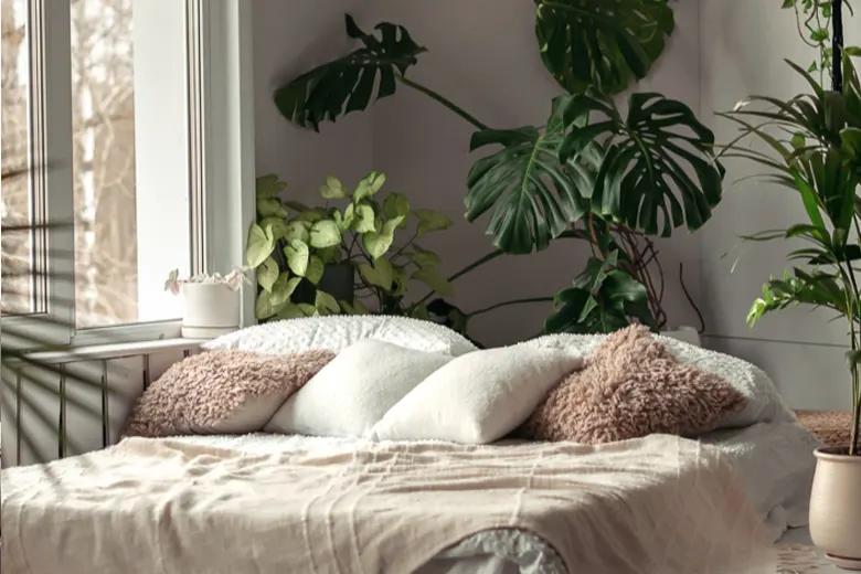 Luxurious bedroom with indoor plants, including potted succulents and trailing vines, enhancing the decor.
