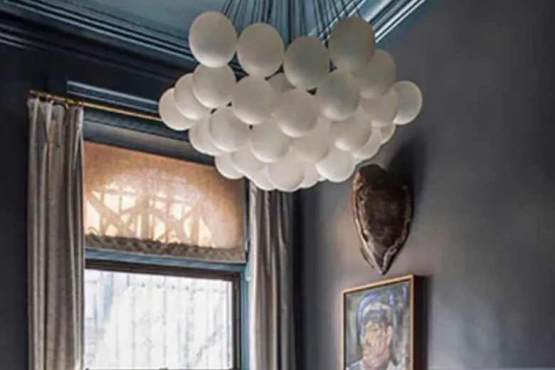 Luxurious bedroom with a chandelier and gold light fixtures illuminating the elegant decor.