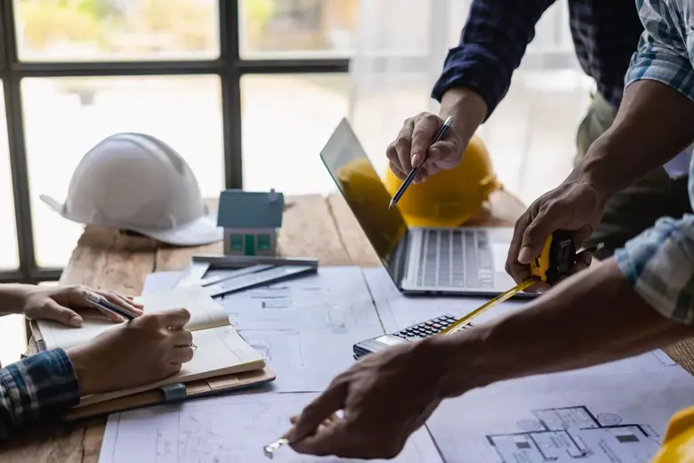 Group of interior designers sketching a building plan Group of interior designers sketching a building plan