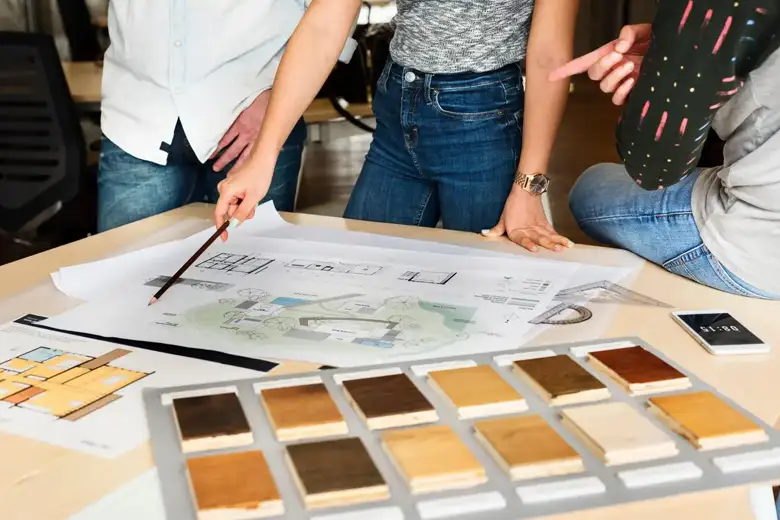 Designers working on the floor plan of a project Designers working on the floor plan of a project