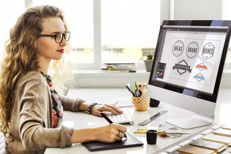 A logo designer browsing logo ideas on her computer for a client. A logo designer browsing logo ideas on her computer for a client.