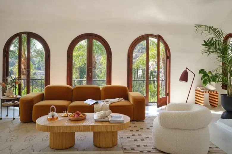 A living room interior featuring marble flooring, an all-wooden table, and a couch in earth tones.
A living room interior featuring marble flooring, an all-wooden table, and a couch in earth tones.