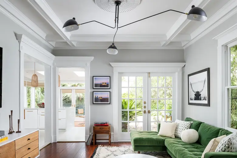 A white den with a green couch A white den with a green couch