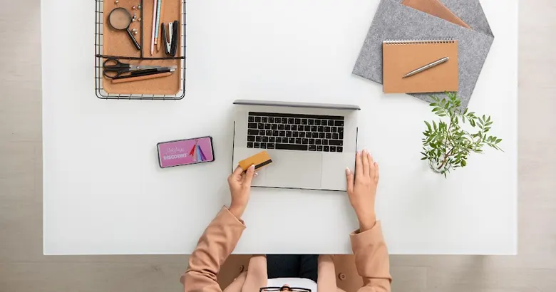 A woman researching graphic designer salary packages for various roles on her computer.