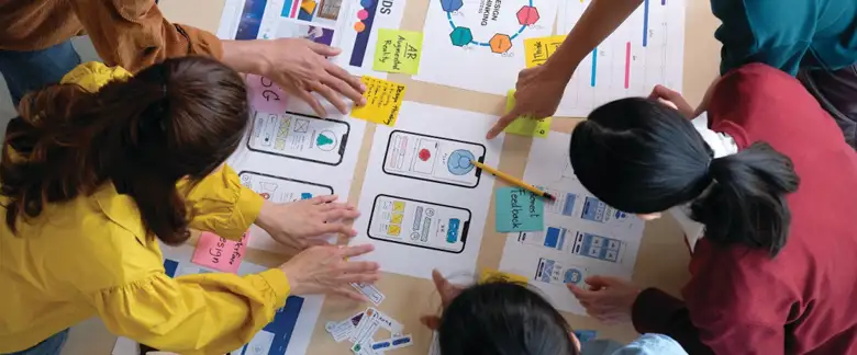 UX developers and UI designers are brainstorming with creative tools and prototypes.
