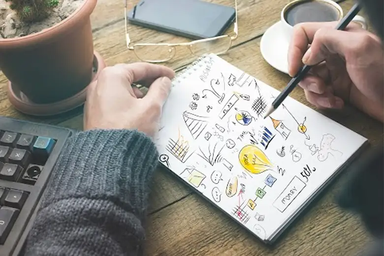 Middle-aged designer researching and sketching ideas for the design thinking process.