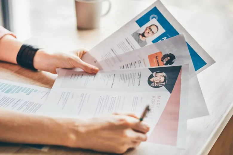A human resource professional handling multiple resumes.
A human resource professional handling multiple resumes.