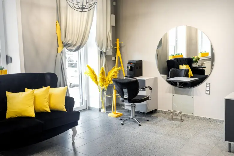 A sleek, modern small salon interior design style with yellow accents.
