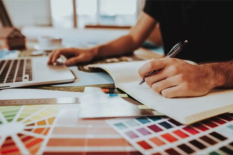 A designer working on brainstorming color scheme for a design.
A designer working on brainstorming color scheme for a design.
