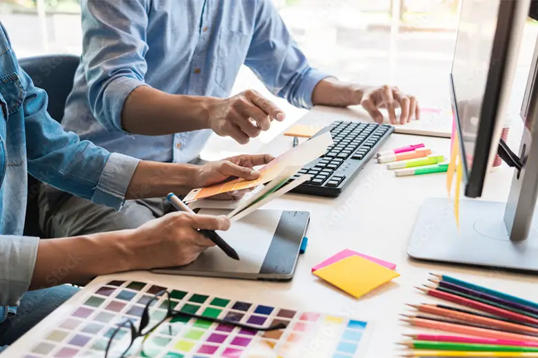 Graphic designers creating designs on a work table.