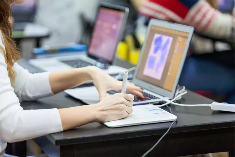 A student attending a class in graphic design school. A student attending a class in graphic design school.