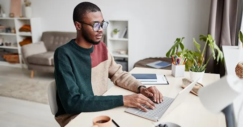 Young employee working on a laptop in a modern small office.
