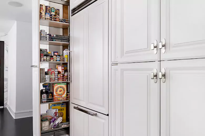 Sleek kitchen with integrated pull-out pantry storage Sleek kitchen with integrated pull-out pantry storage