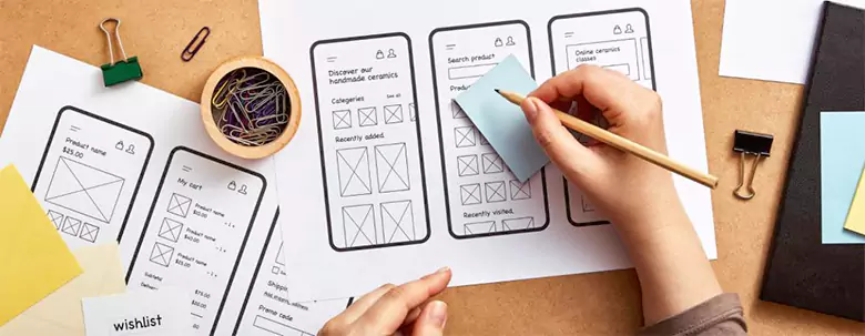 A designer drawing an app wireframe on paper. A designer drawing an app wireframe on paper.