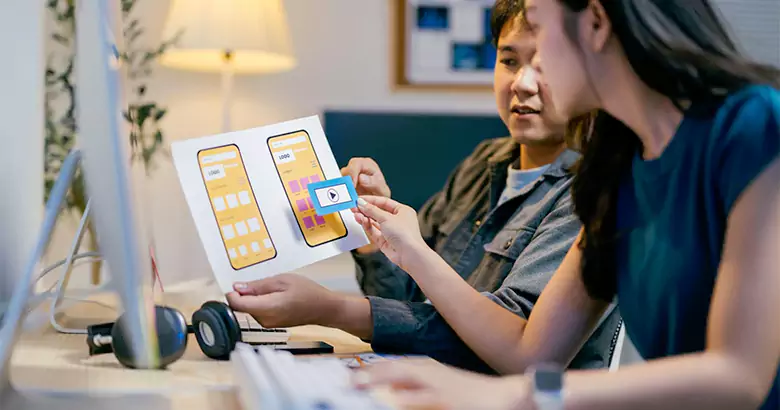 UX designers working on a mobile app wireframe.
