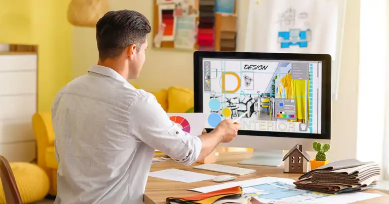 Picture of a man using Adobe InDesign software on a computer.