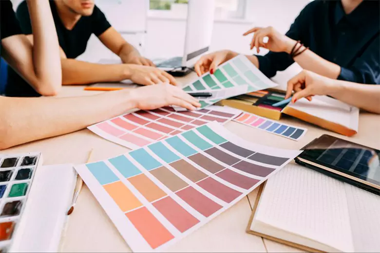 Designers discussing color palette for a visual communication design project.