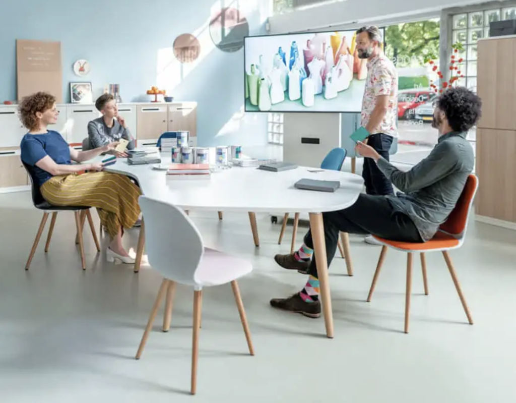 A team gathers at a table in an office with a TV and modern furnitures.
A team gathers at a table in an office with a TV and modern furnitures.