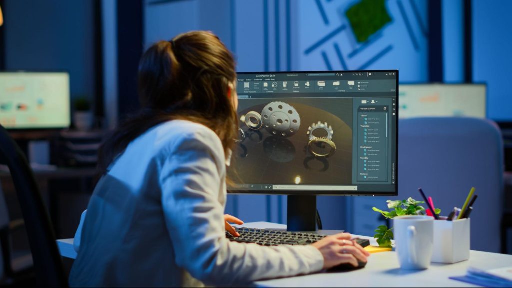 Picture of a woman focused on her computer, designing a product.
