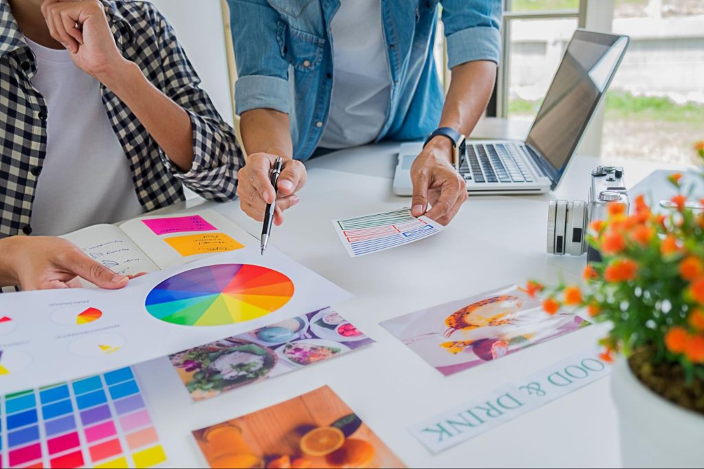 Two team members working on a branding design project at a table, exchanging thoughts and strategies.
Two team members working on a branding design project at a table, exchanging thoughts and strategies.