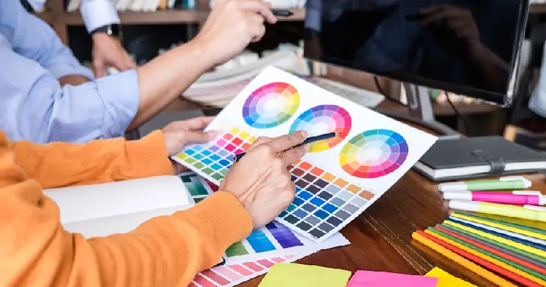 Designer choosing between RGB and CMYK color models for web design.