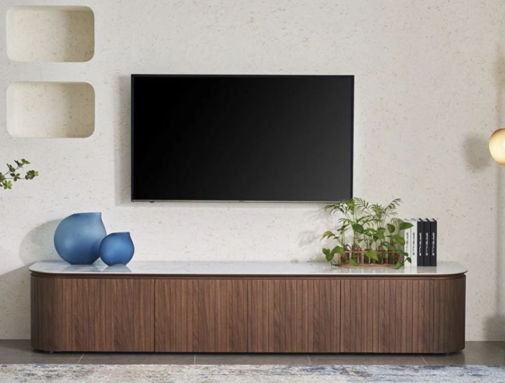 A living room with a TV mounted above a stylish wood and marble table.
A living room with a TV mounted above a stylish wood and marble table.