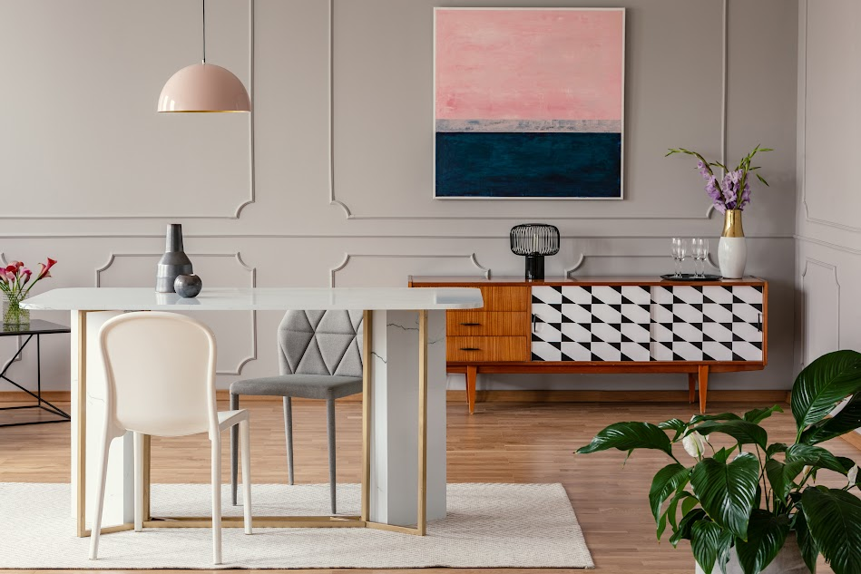 Image featuring a white chair and marble table beneath a pink lamp in an eclectic living room.