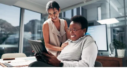 Marketing team laughing together in an office while designing a meme.