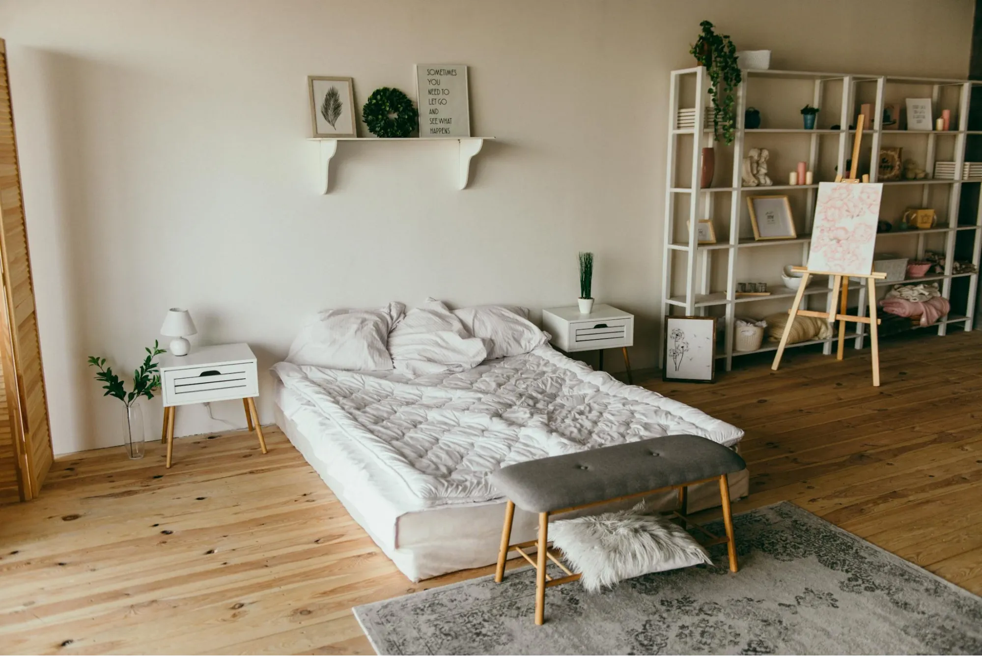 Image showcasing bedroom design idea with soft furnishings and wall hanging.
